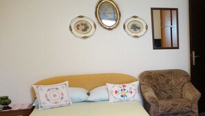 Une chambre à coucher comprenant un lit, deux oreillers, une chaise et trois assiettes décoratives fixées au mur.