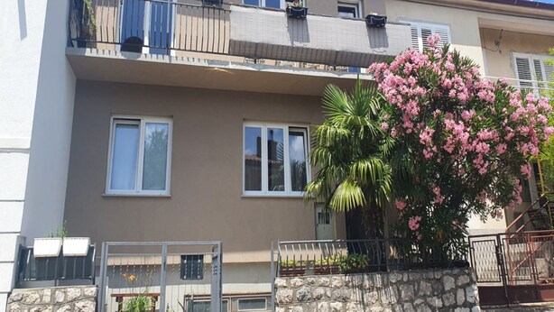 A two-story residential building with balconies, a satellite dish, and a flowering tree. - Family-friendly Apartment Crikvenica (Crikvenica)