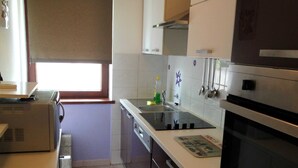 A compact kitchen with a built-in oven, a microwave, and a sink. - Family-friendly Apartment Crikvenica (Crikvenica)