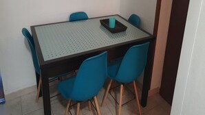 A dining area with a glass-top table, four blue chairs, and a teal candle holder. - Family-friendly Apartment Crikvenica (Crikvenica)