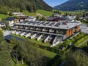 Ein modernes Hotel mit Flachdach, mehreren Balkonen und einem Innenhof.