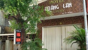 Une enseigne d’hôtel indiquant « HÔTEL JIOANG LAN, LUXE » et une adresse.