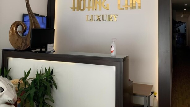 Un comptoir d’accueil avec une pancarte indiquant : « HÔTEL HOANG LAN, LUXE ».