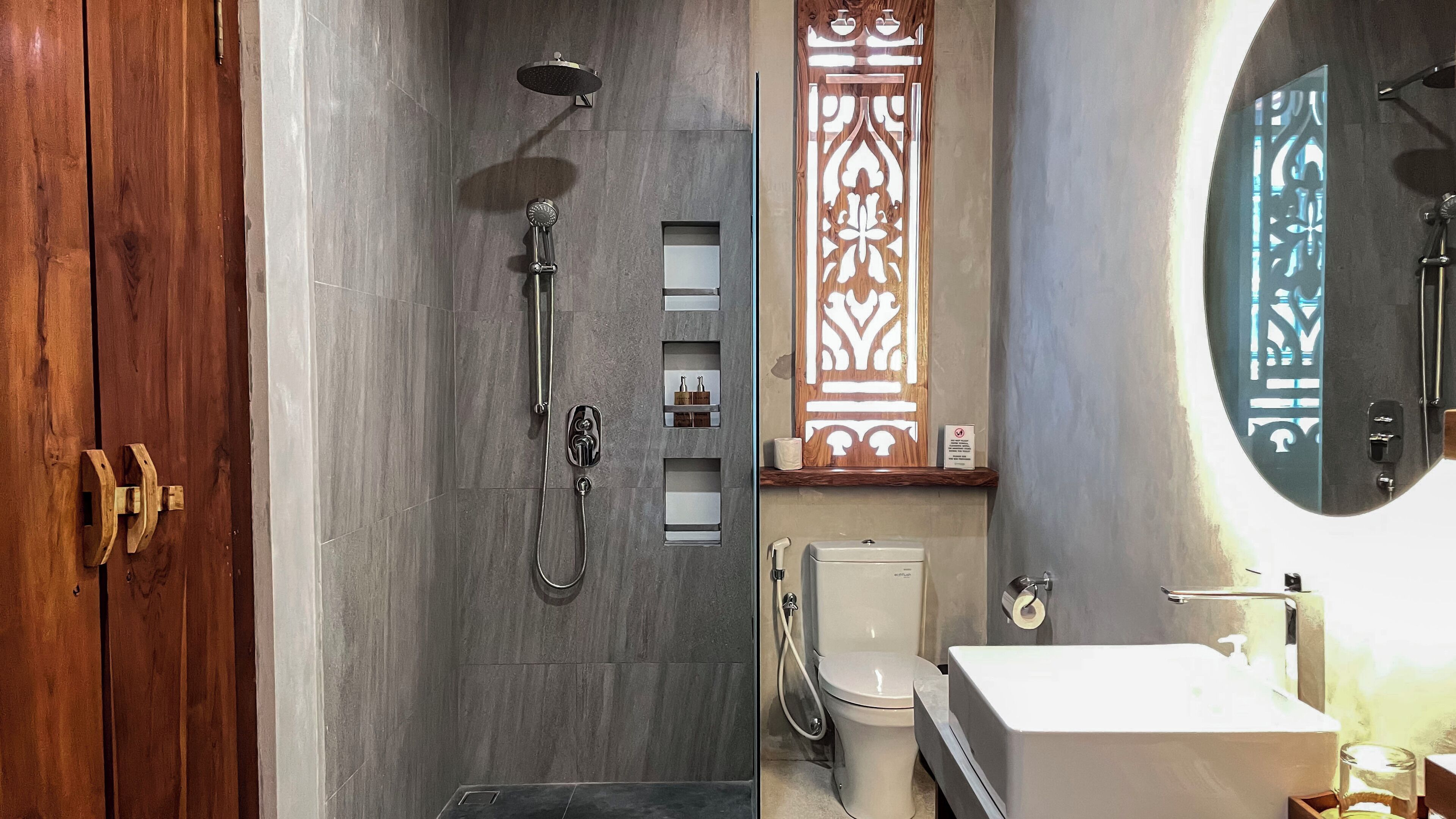A modern bathroom with a shower, toilet, and sink.
