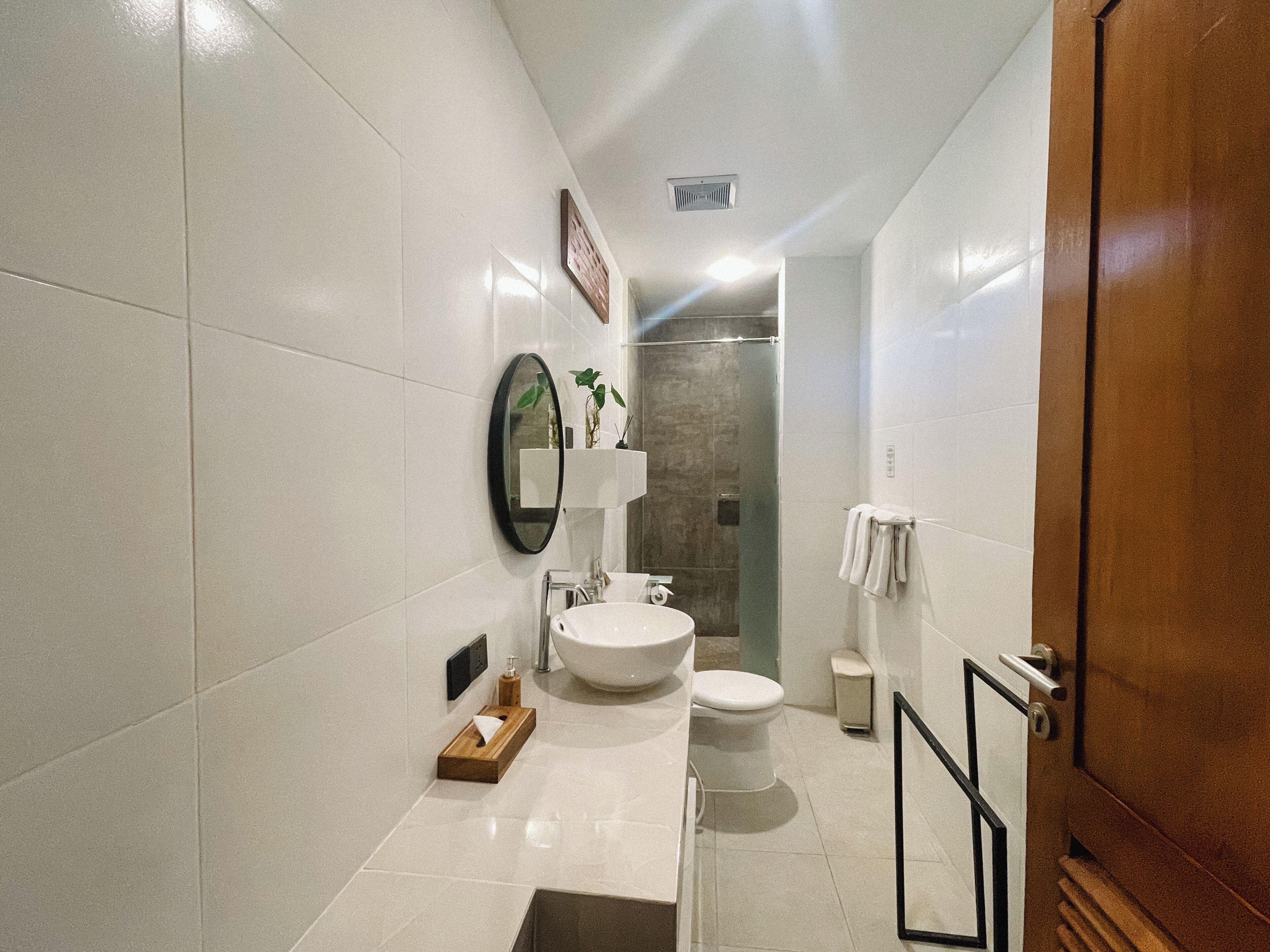 Ein modernes Badezimmer mit großem Waschbecken, Toilette und Duschbereich.