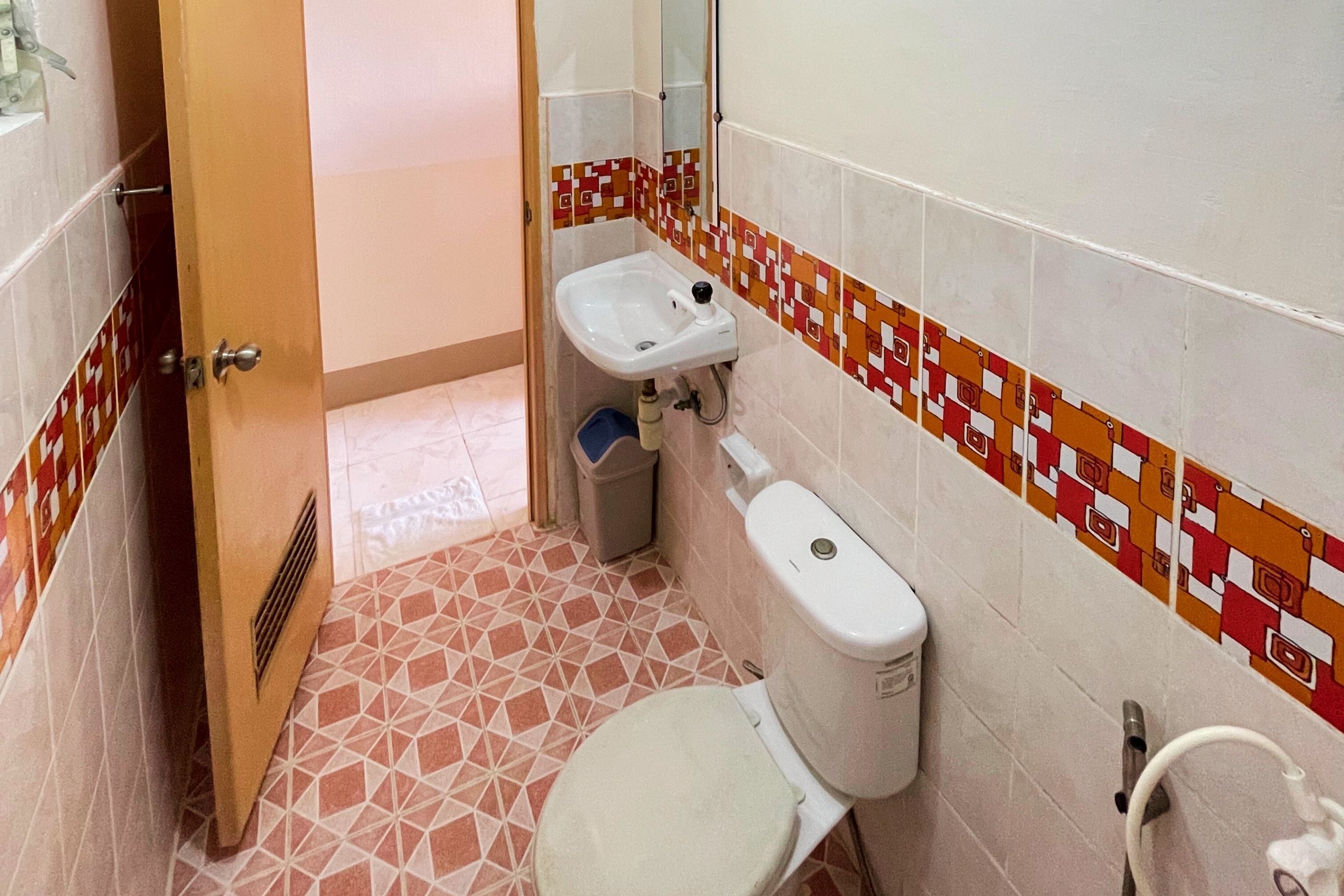 Une petite salle de bain comprenant des toilettes, un lavabo et un espace douche.