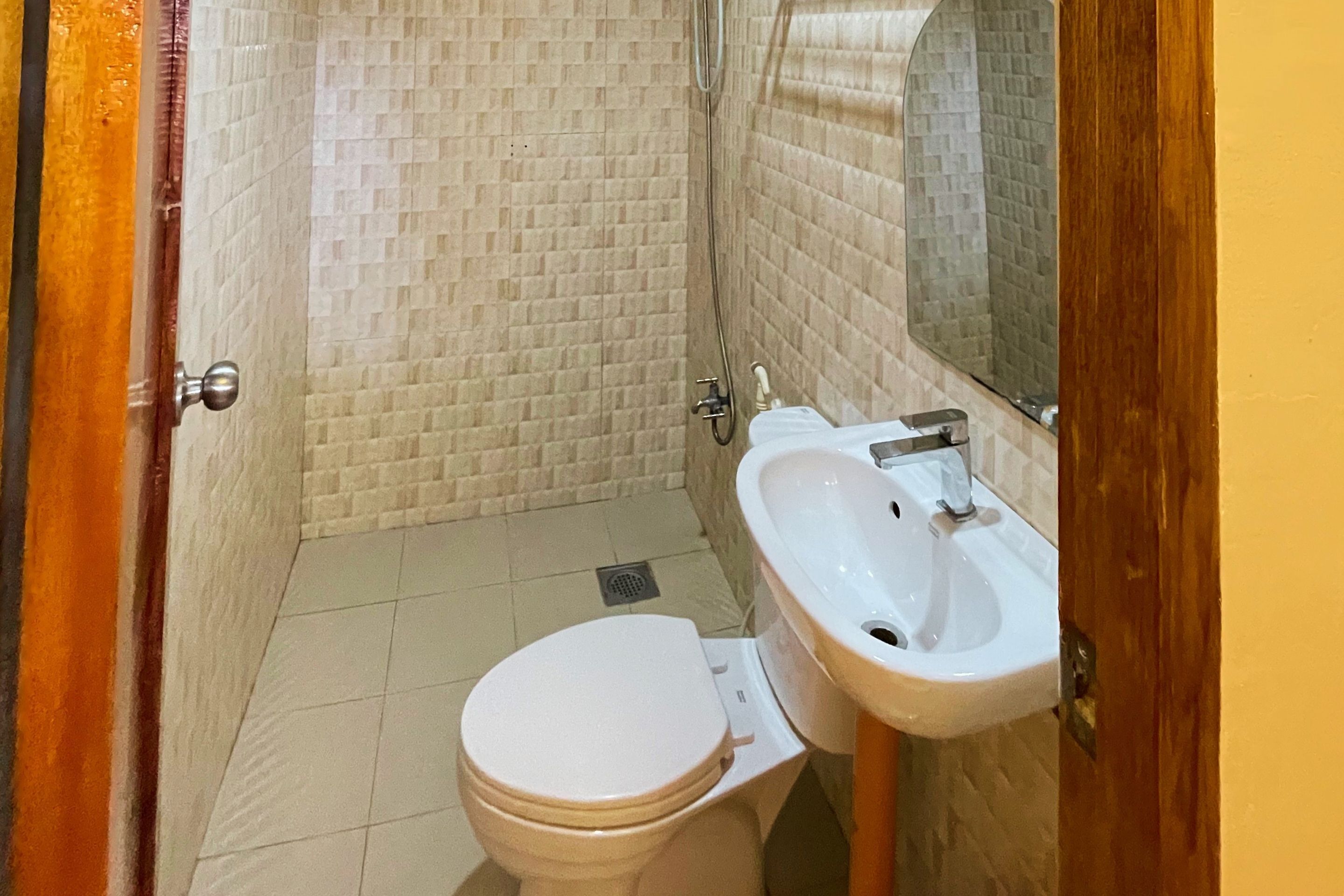 A small bathroom with a toilet, sink, and mirror.