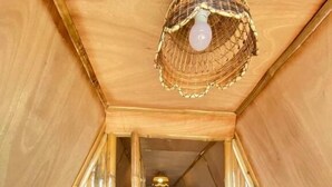 Un interior de madera estrecho con techo inclinado, dos camas y un ventanal pequeño.