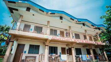A two-story building with balconies, labeled "Durhan White Beach Resort."