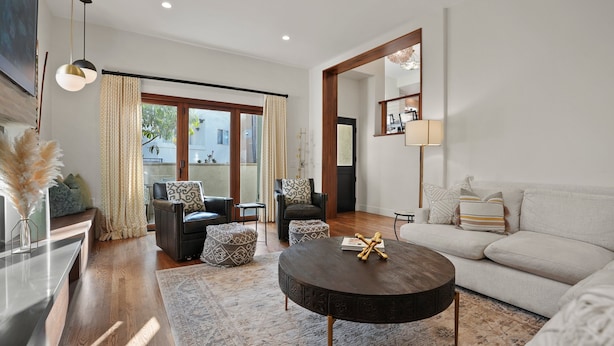 A modern living room with a sofa, a round coffee table, and a dining table.