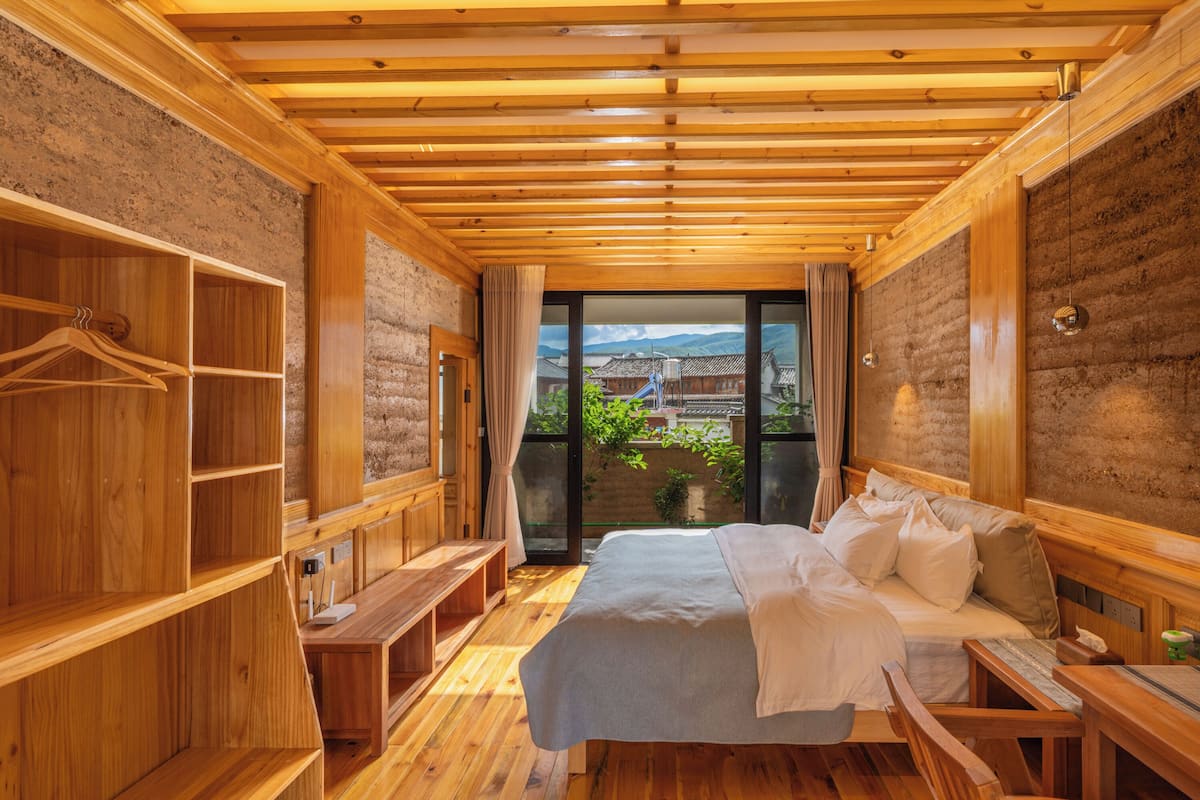 Une pièce en bois avec un lit, un banc et une armoire en bois.