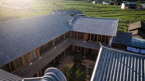 Un bâtiment traditionnel japonais doté d’un toit incurvé et d’une cour intérieure.