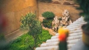 Un bâtiment traditionnel avec un toit en tuiles, un mur en pierre et un escalier menant à l’étage.