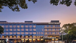 Un hôtel moderne doté d’une façade en verre, de plusieurs étages et d’une enseigne bien visible indiquant « HYATT PLACE ».