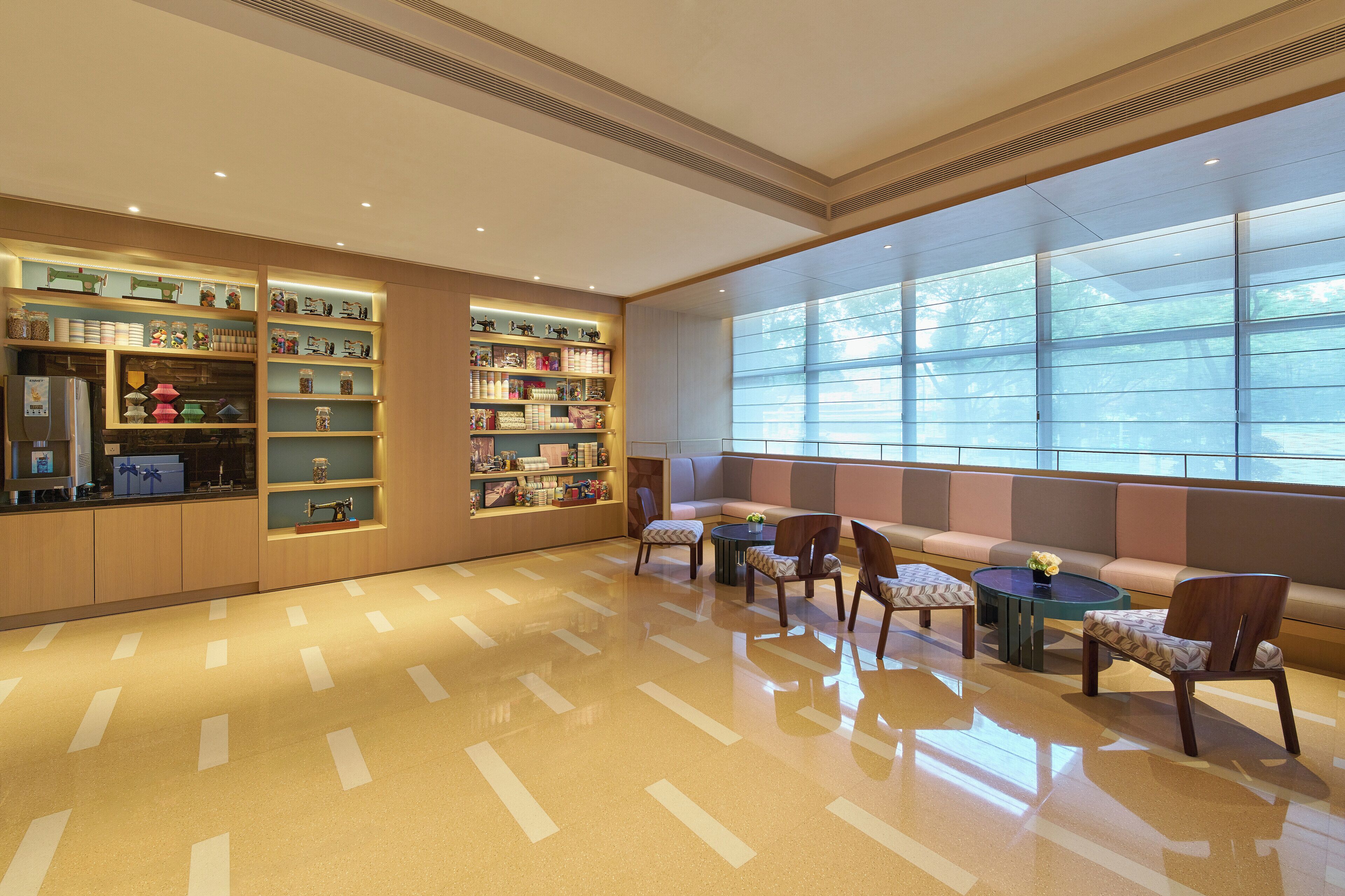 A spacious lobby with a polished floor, seating area with sofas and chairs, and a large window providing natural light.