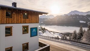A building with a wooden facade and a sign for ALPS RESORTS. - Studio near the slopes with wellness area (Mittersill)