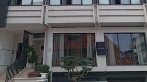 Et moderne hotel med flere etager, med altaner, store vinduer og et skilt, der angiver, at der tilbydes værelser og suiter.