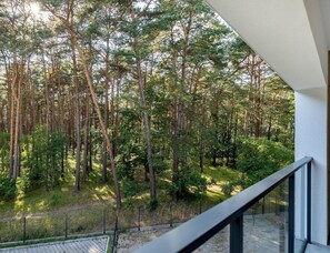A balcony with a view of a dense forest. - Holiday Studio With air Conditioning, Summer Pool (Dziwnów)