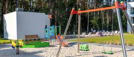 A playground with swings, slides, and a sandpit.