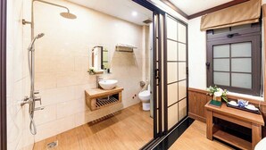 Un baño moderno con ducha, lavamanos, inodoro y tocador con espejo.