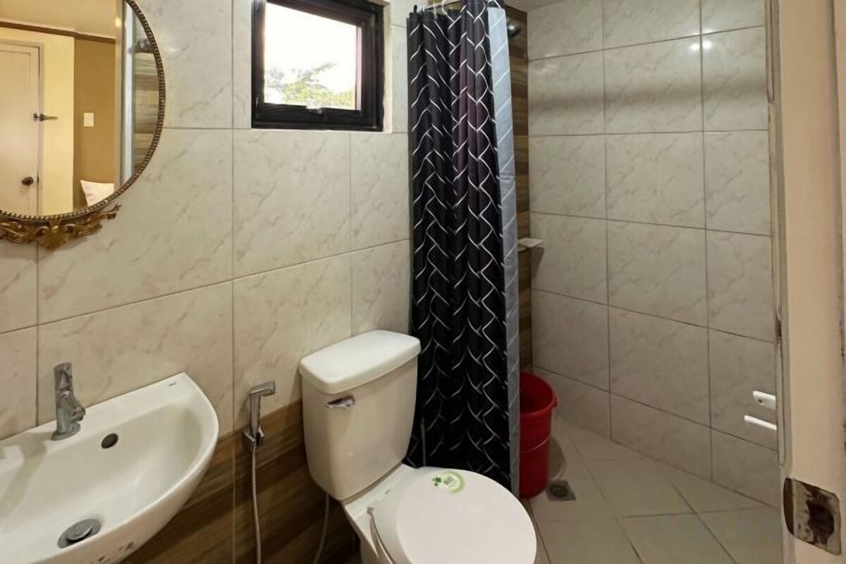 Une salle de bain avec des toilettes, un lavabo et une douche.