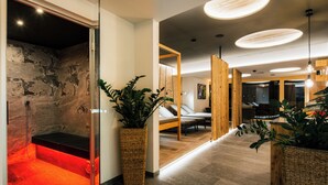 A modern spa area with a heated floor, a massage table, and a wooden reception desk. - Ferienresidenz Raich (Ried im Oberinntal)