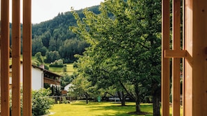 A wooden pergola structure with a view of a grassy yard and trees. - Ferienresidenz Raich (Ried im Oberinntal)