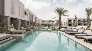 Una piscina al aire libre de temporada, sombrillas