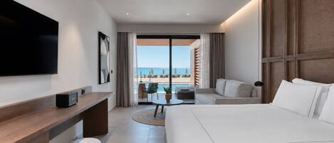 Una habitación de hotel moderna con una cama grande, un escritorio, un televisor de pantalla plana y un balcón con vistas a la playa.