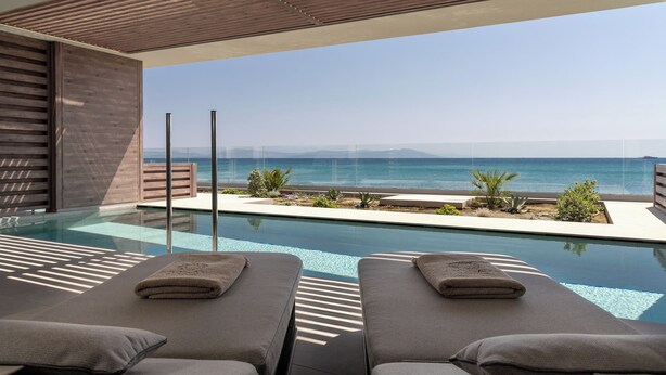 A modern poolside area with two lounge chairs, a clear view of the ocean, and a minimalist design. - Mosay All Suite Hotel - Adults friendly (Kos)