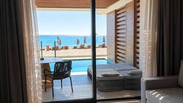 Una habitación moderna con puerta de cristal que da a una piscina y vista al mar.