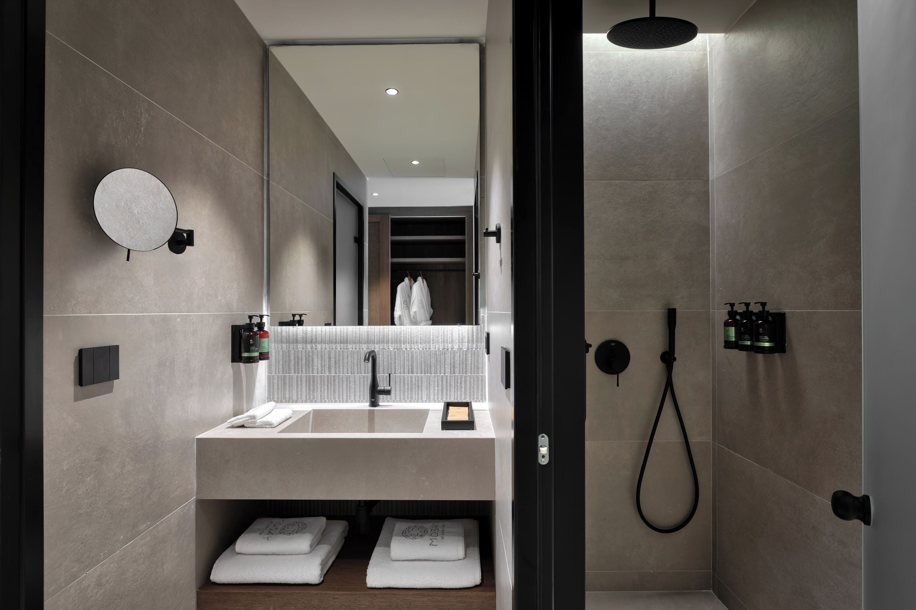 Een moderne badkamer met een grote spiegel, een wastafel en een douche.
