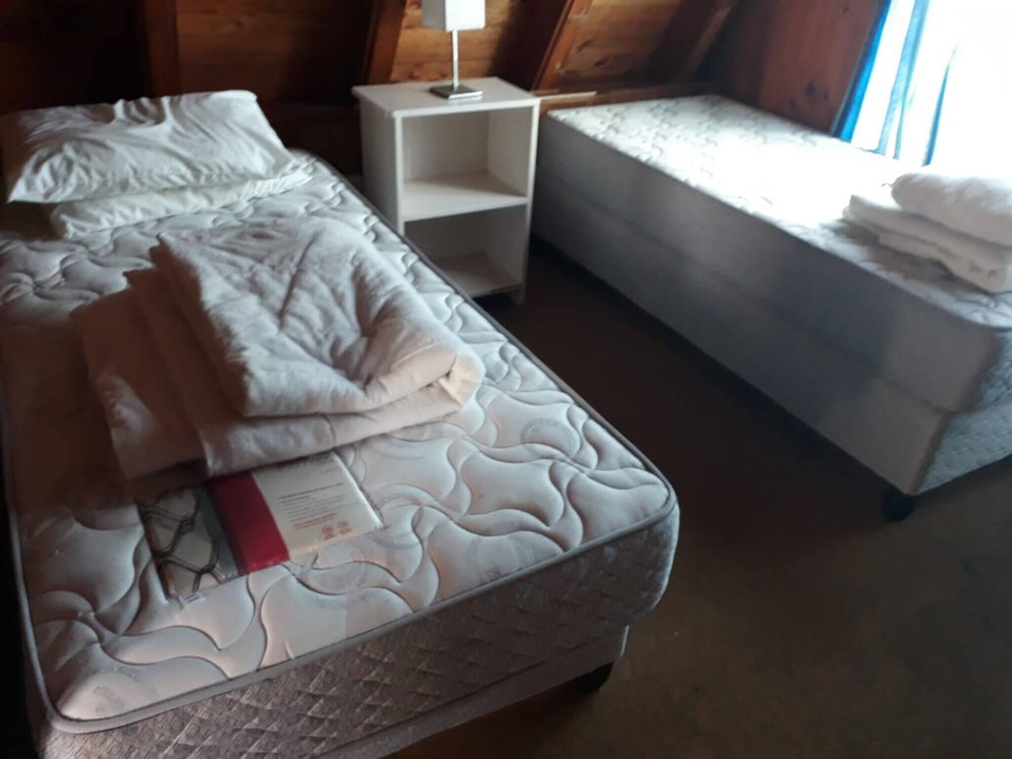 A bedroom with a bed, a bedside table, and a small sofa.