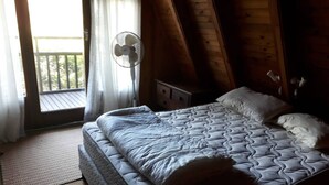 Une chambre avec un lit, un ventilateur et une vue sur l’extérieur.