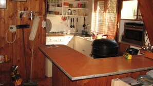 Une cuisine de taille réduite, avec des meubles de rangement en bois, une cuisinière et un four à micro-ondes.