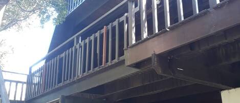 Una estructura de madera de varios niveles con una escalera y un balcón.