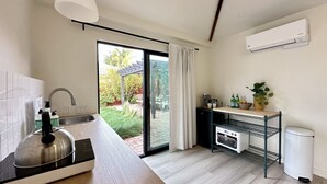 Eine moderne Küche mit Einbauherd, Spüle und einer Schiebetür zu einem Garten.