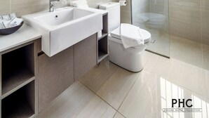 A modern bathroom with a large sink, toilet, and glass shower enclosure. - Hutton Suites Hotel Managed By The Ascott Limited (George Town)