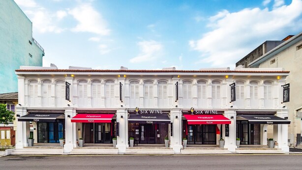 A building with two 'SIX WINE' restaurants and a 'Hutton' hotel. - Hutton Suites Hotel Managed By The Ascott Limited (George Town)