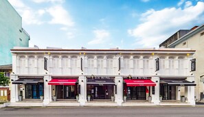 A building with two 'SIX WINE' restaurants and a 'Hutton' hotel. - Hutton Suites Hotel Managed By The Ascott Limited (George Town)