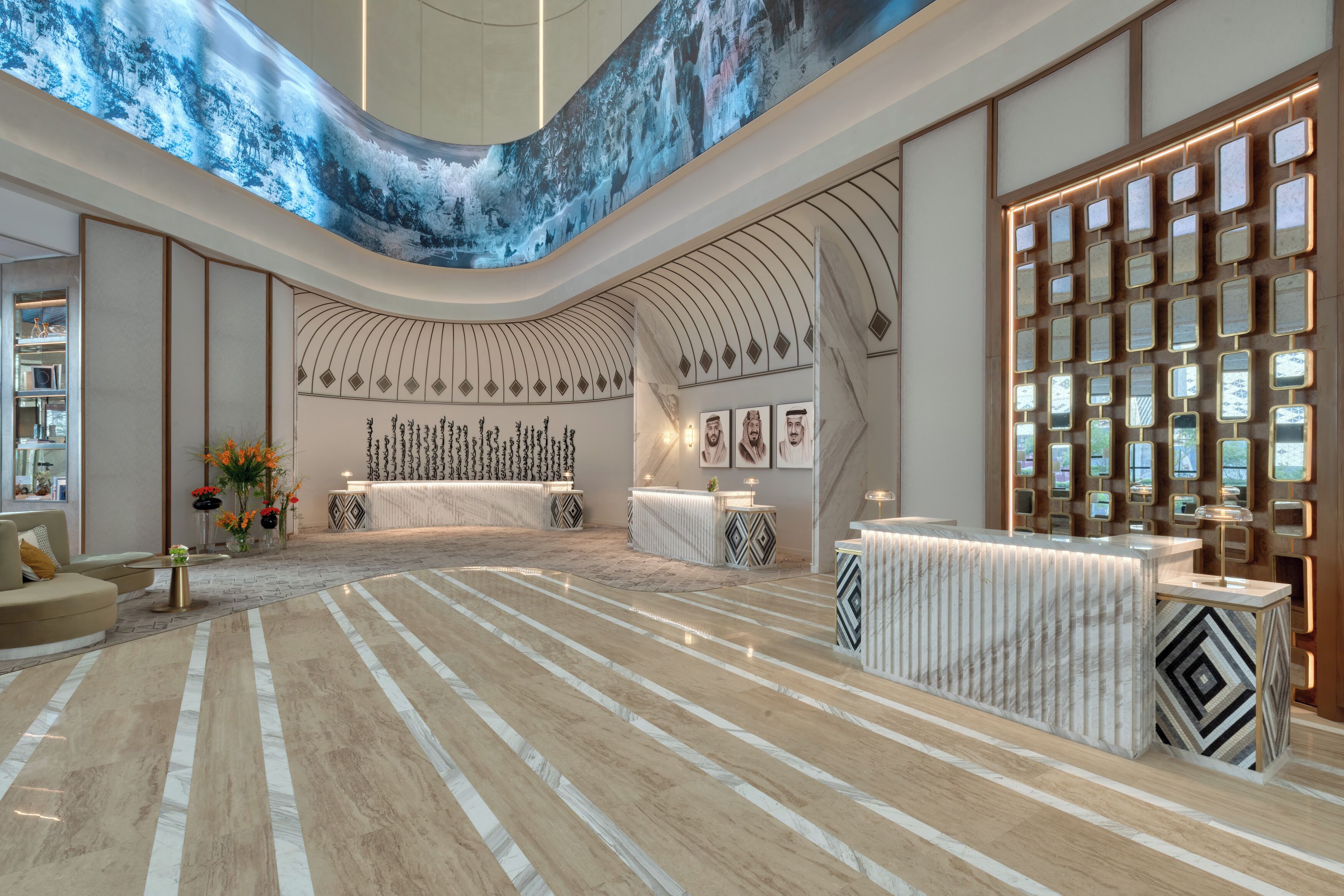 A spacious lobby with a curved ceiling, a reception desk, and a patterned floor.