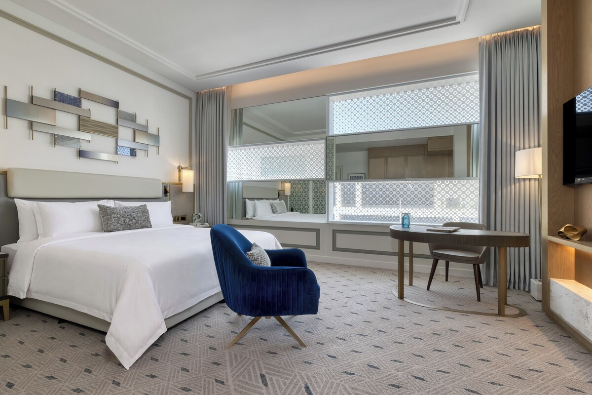 Habitación de hotel con una cama grande, un escritorio y una silla.