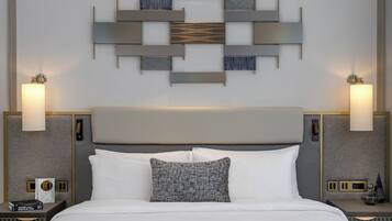 A hotel room with a large bed, two bedside tables, a wall-mounted light fixture, and a decorative wall panel.
