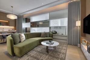 Una sala moderna con un sofá modular, una mesa de centro y un televisor montado en la pared.