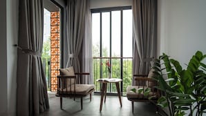 A room with two chairs, a small table, and a potted plant.