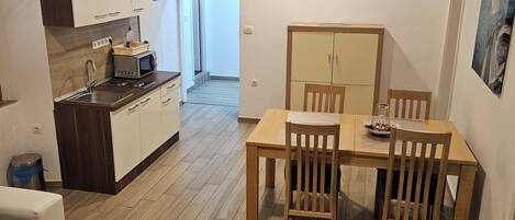 A modern apartment with a kitchen, dining area, and living room.