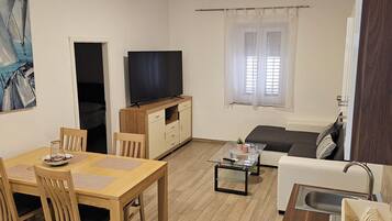 Apartamento conforto, 2 quartos | Área de estar | TV de tela plana