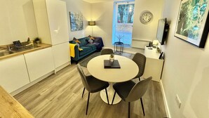 A compact living space with a kitchenette, a dining area, and a sofa.