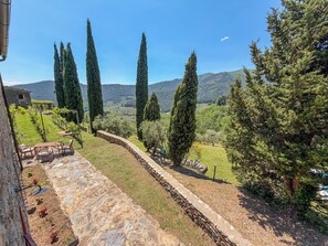 A stone pathway leading to a seating area with a view of a vineyard and distant mountains. - 2 houses with private pool 20km from Pisa, Lucca and 30 from the sea (Toscana)