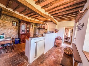 A rustic kitchen with exposed wooden beams, a stone wall, and a tiled floor. - 2 houses with private pool 20km from Pisa, Lucca and 30 from the sea (Toscana)